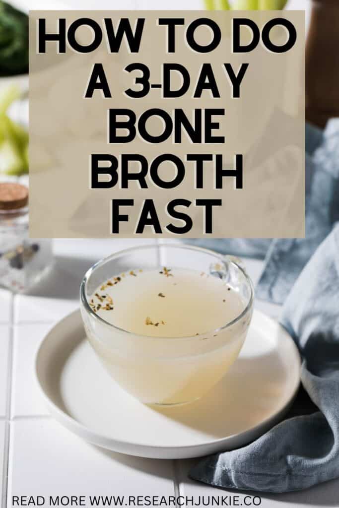 A Glass mug filled with bone broth and herbs sitting on a white round dish that is on a white kitchen counter